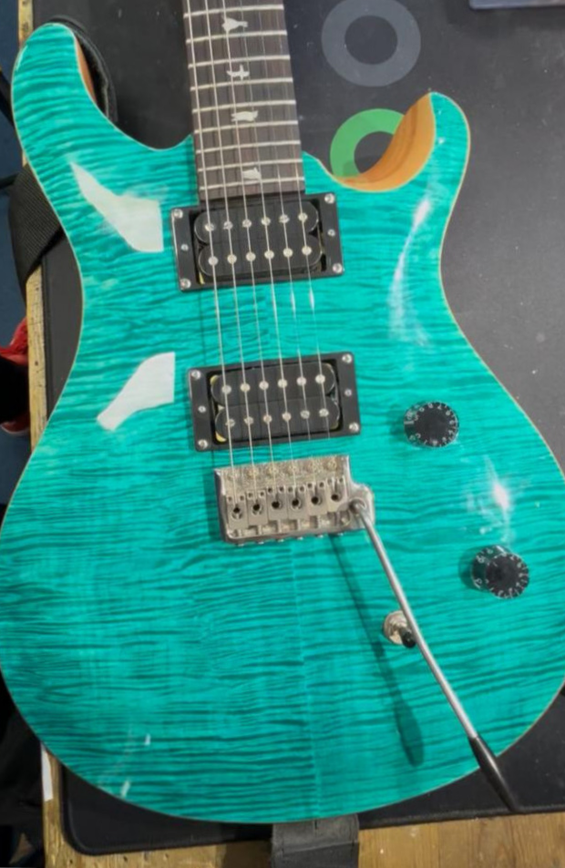 Turquoise electric guitar on the workbench